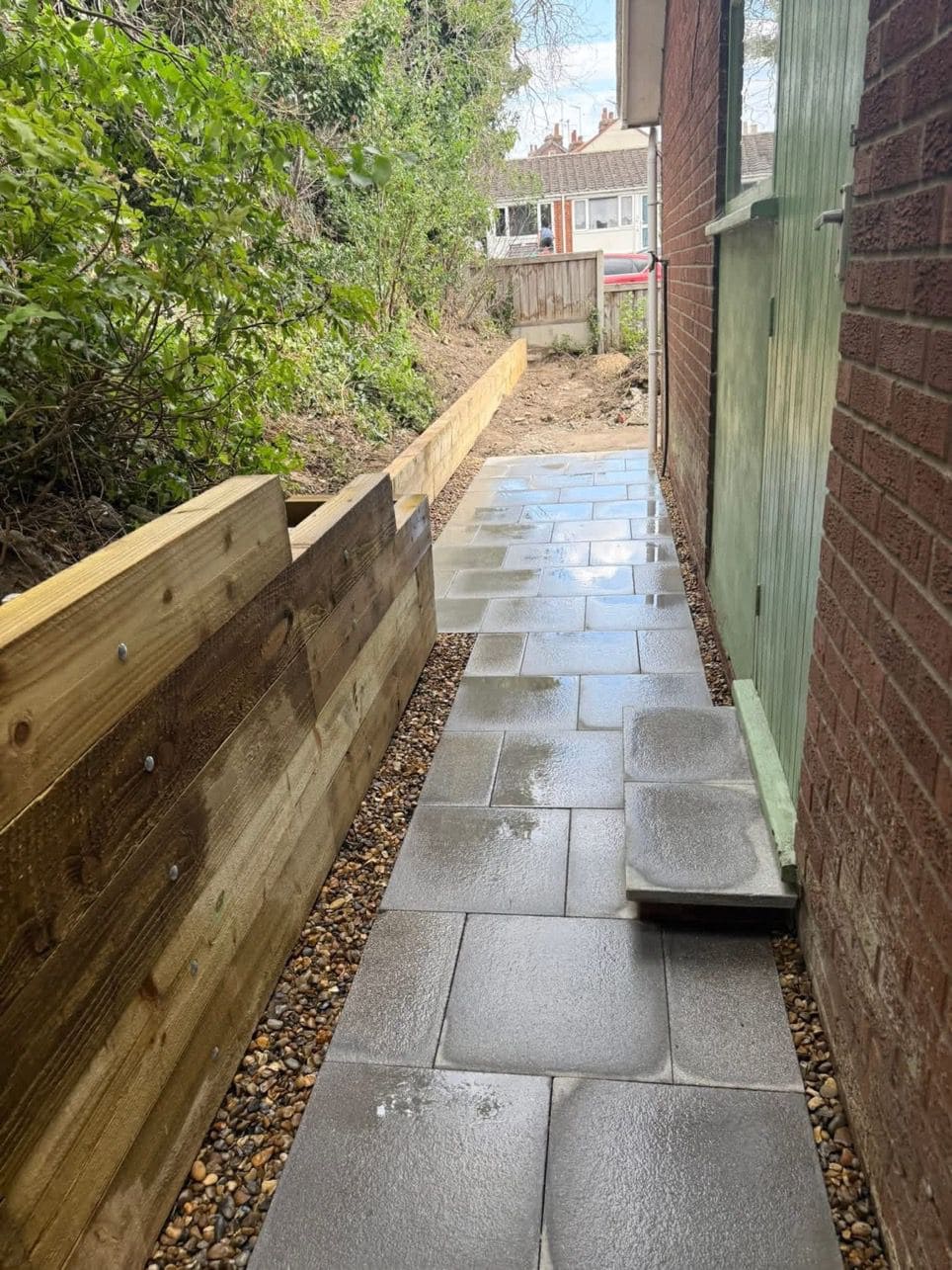 Patio pathway with retaining wall alongside residential property