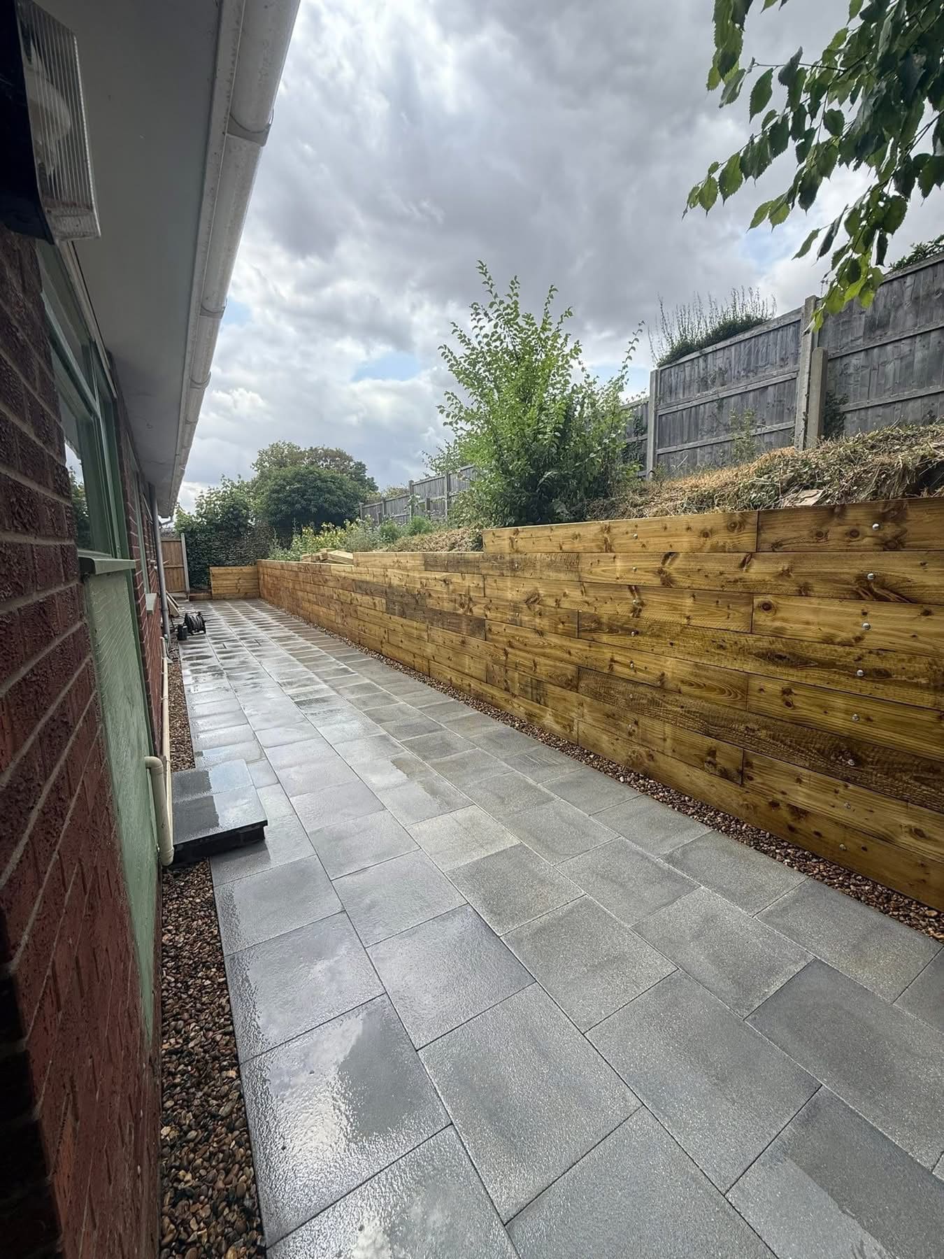 Side garden retaining wall with gravel and planting